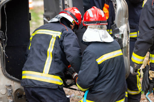 firefighters using hydraulic tools during a rescue operation training. rescuers unlock the passenger in car after accident. high quality 4k footage - driving training car safety foto e immagini stock