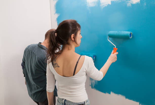 istock Woman painting wall 1925970228