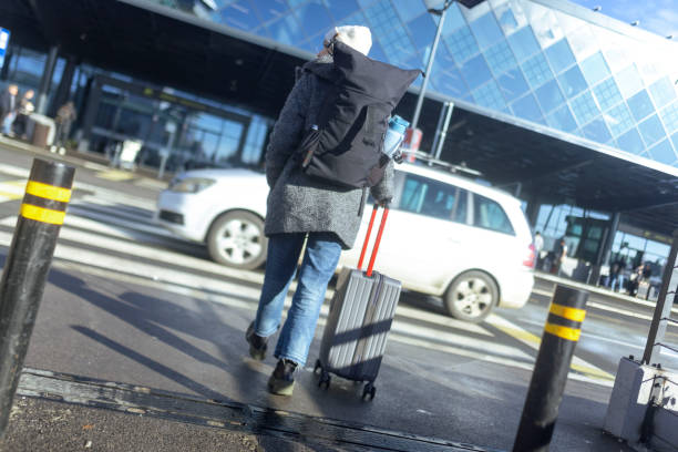 istock An unrecognizable female tourist with a backpack on her back crosses the pedestrian crossing and heads towards the airport 1925975037