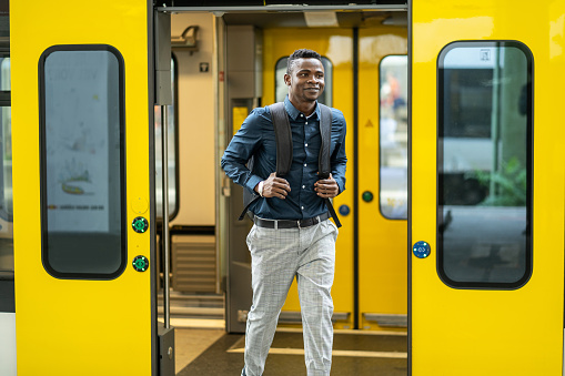 Portrait of handsome african commuter in front of subway car