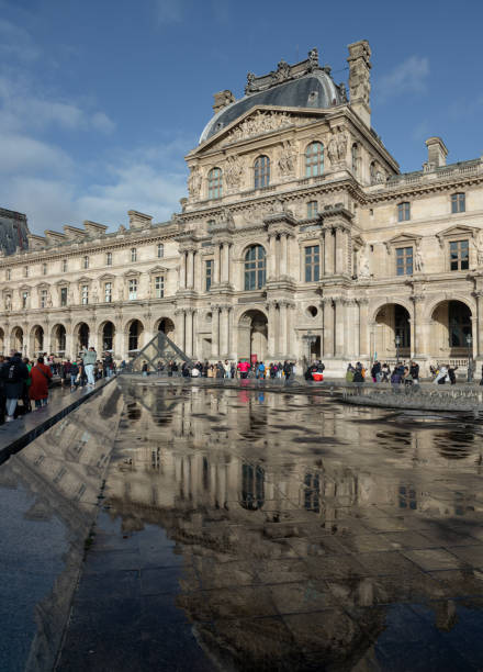 France, Paris - Jan 03, 2024 - View of The historical palace building with water reflection effect by after raining at the Louvre museum in Paris. is one of the world's largest museums in Paris, Space for text, Selective focus.