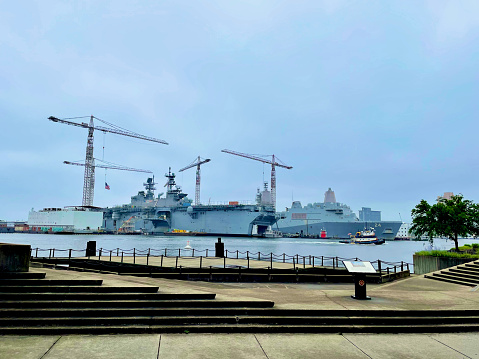 Norfolk, Virginia, USA - May 30, 2023: U.S. Navy ships USS Iwo Jima (LHD-7) and USS Arlington (LPD-24) are repaired at General Dynamics’ NASSCO-Norfolk facility at the confluence of the North Elizabeth River and South Elizabeth River.