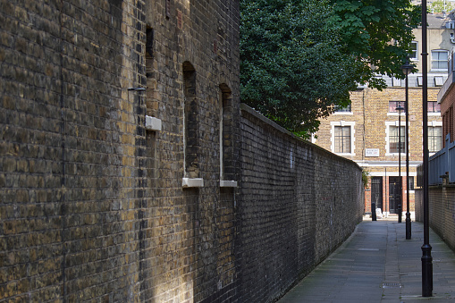 London, UK - 7 May 2020: An alleyway in London with old fashioned black lampposts