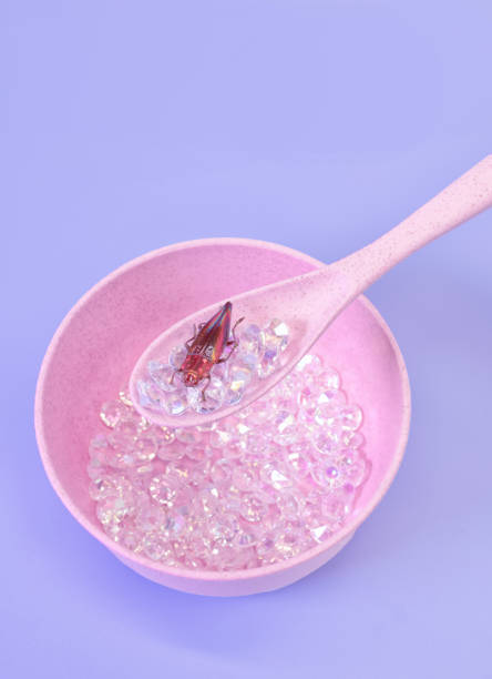 istock A Bowlful or Iridescent Diamonds in a Pastel Pink Bowl and a Beautiful Iridescent Beetle Bug on a Spoon 1926010951