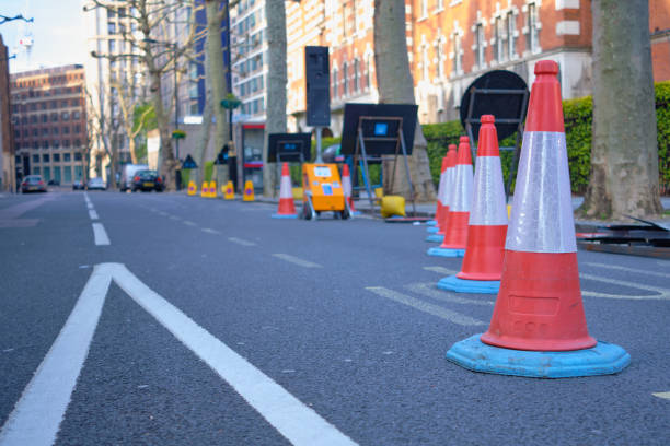 Roadwork cones on street with back of temporary traffic lights.