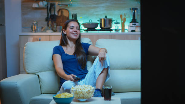 istock Woman laughing watching tv 1926012569