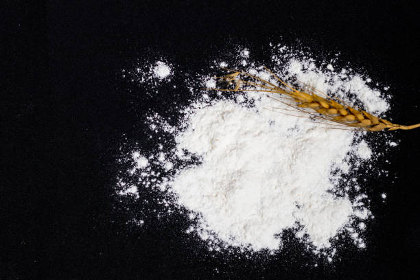 istock Wheat ears and flour on black background 1926013017
