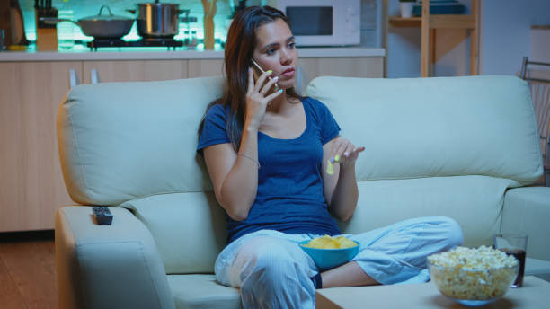 istock Speaking on phone holding snacks bowl 1926014927