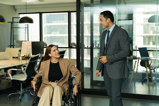 Two businesspeople talking in the hallway in an inclusive office