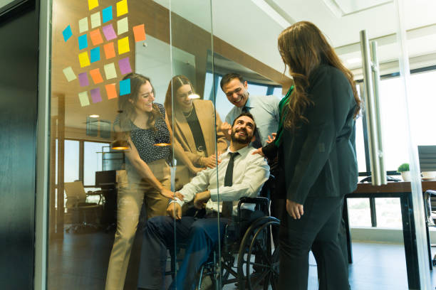 istock Group of people recognizing a disabled person's work in an inclusive office 1926080807