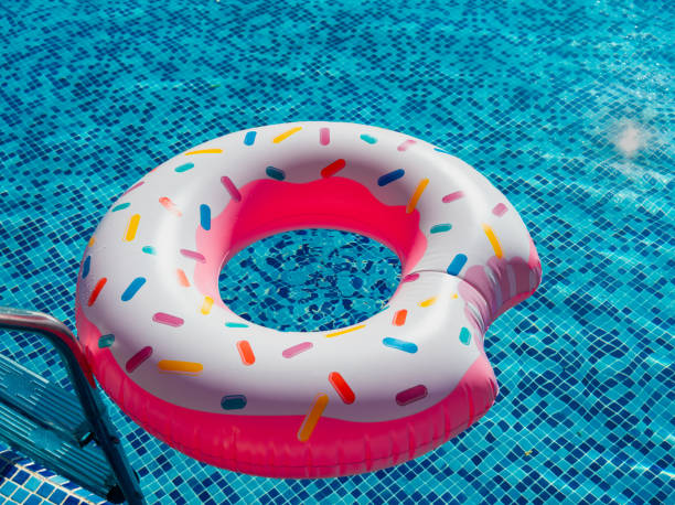 istock A toy rubber bitten donut with caramel sprinkles next to the pool railing 1926107629