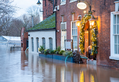 Worcester,Worcestershire,UK-January 03 2024:Flood waters,caused by recent winter rains,storms and high river levels,enter a riverside pub,as efforts are made to cear it by water pumps.