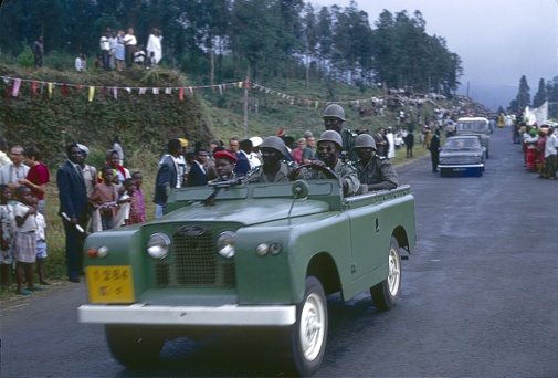 Cameroon (exact location unfortunately not known), 1967. Presidential guard driving ahead in a Land Rover on a state visit to Cameroon. Also: spectators.