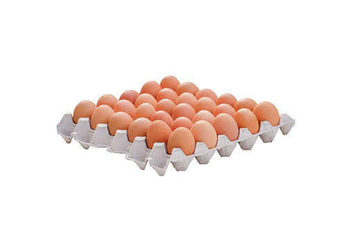 Stock photo showing close-up view of batch of ten mixed white and brown coloured eggs in open disposable cardboard egg box on green background.