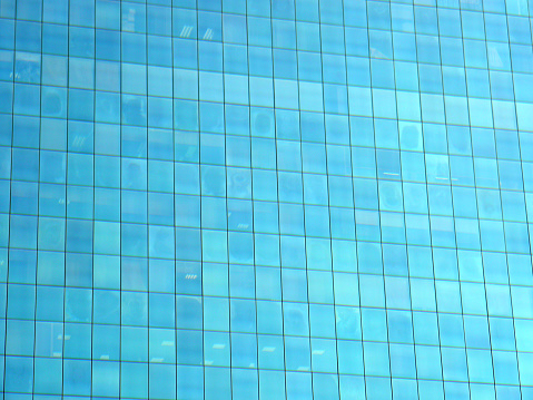 Building glass, glass building on cloudy blue sky background, blue sky reflected in windows of modern office building.