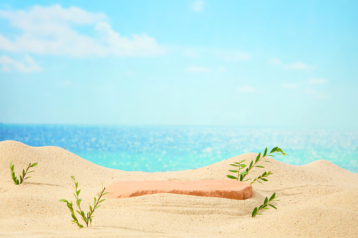 Brick podium with copy space for product display presentation on background of sand, sea and blue sky. Minimal scene for advertising with summer vacation concept