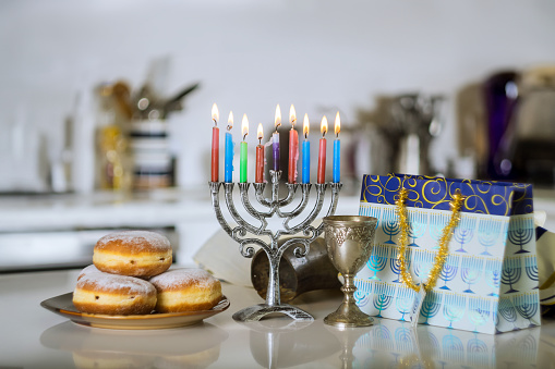 Hanukkiah Menorah candle is lit during traditional celebration of Hanukkah Jewish holiday