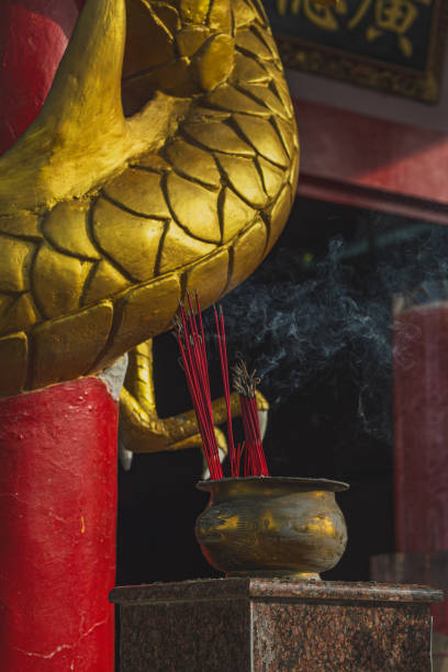 Two men putting incense onto an incense burner in a Taoist temple in Lukang, Taiwan. One person is slightly mobility impairment.
