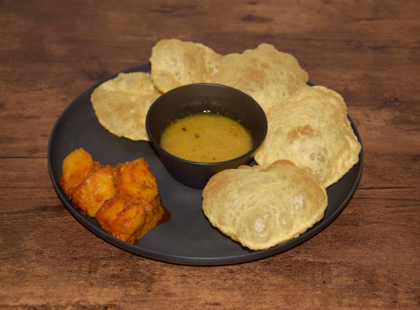 istock Bengali traditonal dish Luchi with Aloor Dum and Cholar Daal. Luchi is deep fried bread with potato curry and yellow lentil 1926220750