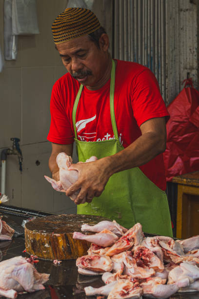 a man is checking and cleaning the chicken meats at his shop in Pasar Baru, Balikpapan city. stock photo