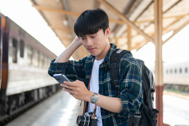 istock A confused Asian tourist backpacker is checking his train ticket on his phone at a railway station. 1926222295