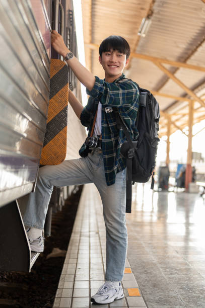 istock A happy Asian man backpacker is getting on the train, travel somewhere on his summer vacation. 1926249540