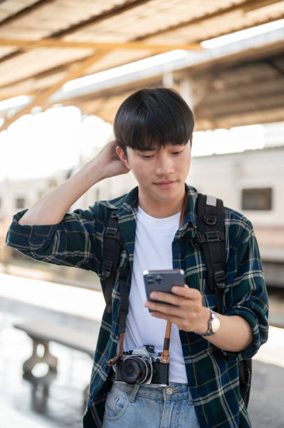 istock A confused Asian tourist backpacker is checking his train ticket on his phone at a railway station. 1926258844