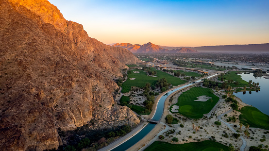 Dramatic aerial view at sunrise over the Coachella Canal and mountains in La Quinta.  Mountains in the distance.