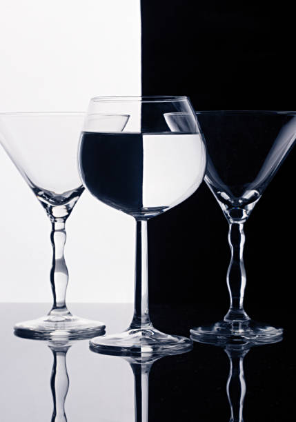 Three wine glasses isolated on black and white splited background. Beautiful lightning