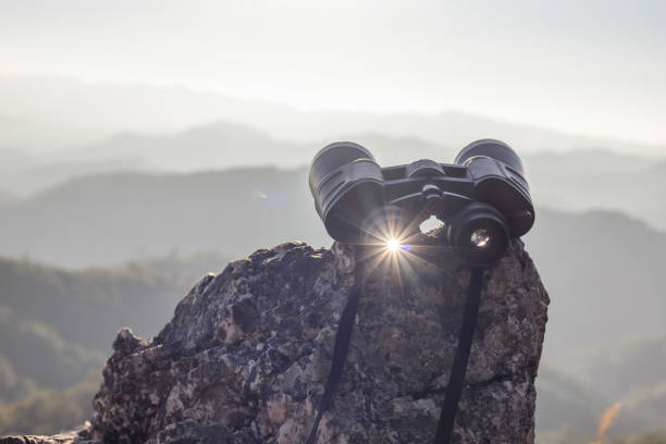istock binoculars on top of rock mountain at beautiful sunset background. 1926306543