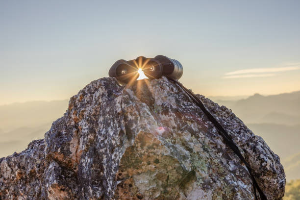 istock binoculars on top of rock mountain at beautiful sunset background. 1926306547