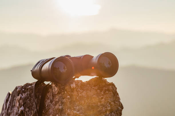 istock binoculars on top of rock mountain at beautiful sunset background. 1926306549