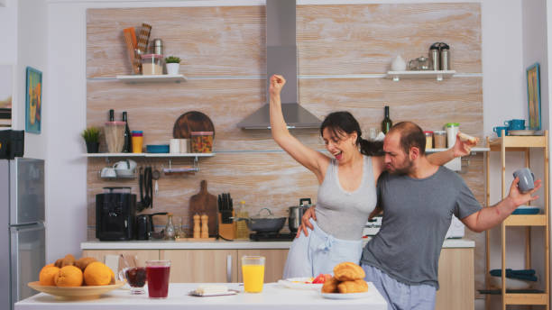 istock Carefree couple dancing and singing in kitchen 1926340820