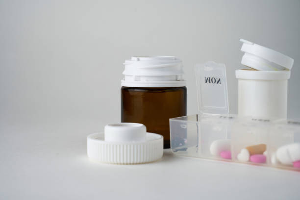 Medical pills and capsule on a white background with copy space. Prescription pills and bottles with weekly pill organizer for daily treatment