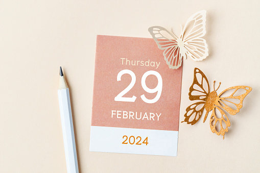 February 29th mini calendar for February 2024 and butterfly paper on yellow background. Leap year, intercalary day, bissextile.