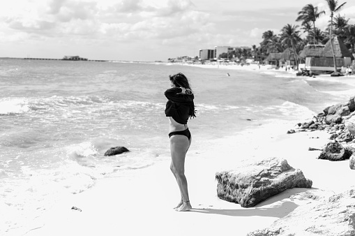 Woman in the beach with black swimwear