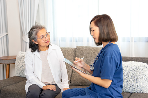 asian senior woman interested in a female nurse using digital tablet,giving advice self health care at home,concept of elderly health care,home care,home health care