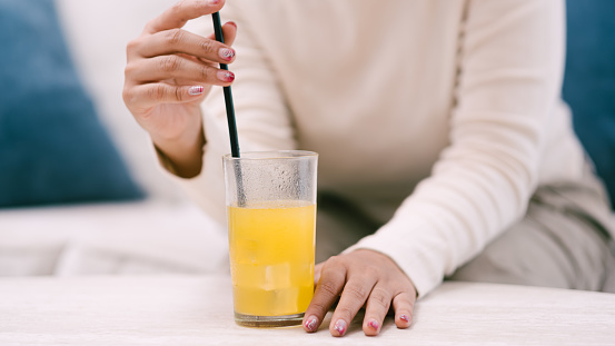 Effervescent tablet of vitamins in a glass of water. Orange antiviral drink. On a black background, close-up.