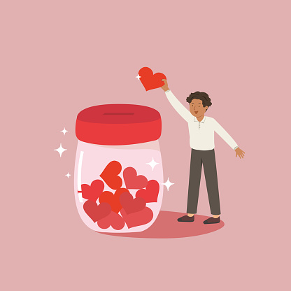 Young man holding red heart and giving to jar.  Concept for sharing love, helping others and charity.