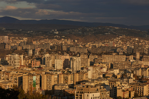 A scenic view of Tbilisi surrounded by majestic mountains in the distance at sunrise in Georgia