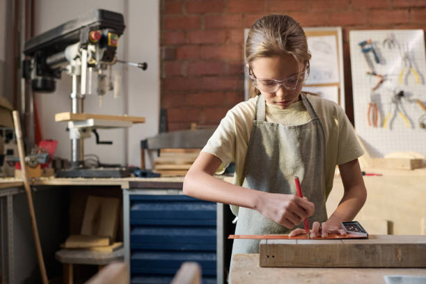 istock Girl Measuring Building Model in Carpenting Workshop 1926656011