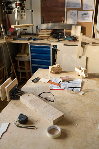 High angle view at workstation with tools in carpentry workshop lit by sunlight, copy space