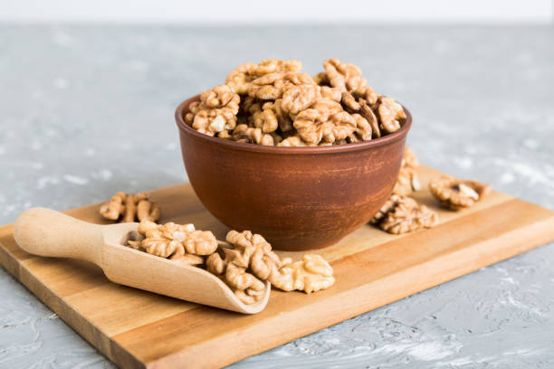 istock Fresh healthy walnuts in bowl on colored table background. Top view Healthy eating bertholletia concept. Super foods 1926660248
