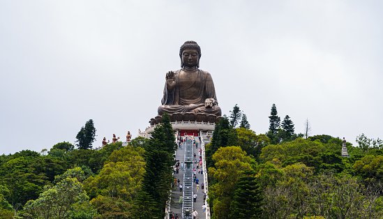 Tiantan Buddha or Big Buddha in Hong Kong. Closeup group of pople are walking up the stairs to the Buddha to pay their respects. Pray for faith.