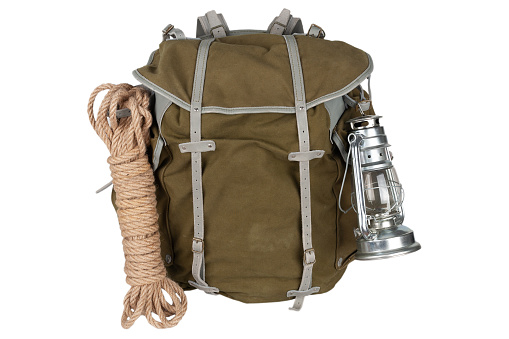 Antique vintage backpack with rope and gas lantern isolated on white background