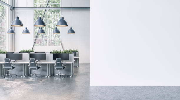 istock Semi-empty office interior with white wall and copy space,  work desks and large windows  on concrete floor 1926737301