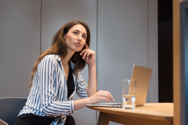 istock Thoughtful lady sitting at table with opened laptop 1926750573