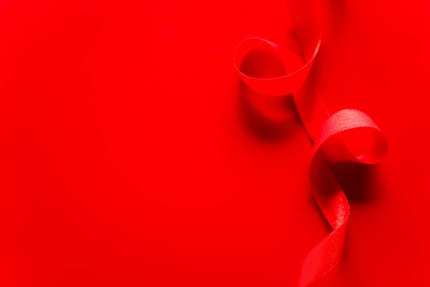 istock red satin ribbon frame on red background with copy space for text. 1926754208