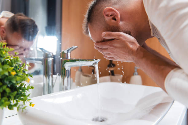 istock Bearded man splashing water on face in morning 1926764706