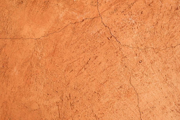 istock Cracked orange clay wall texture background for interior or exterior design. 1926768357